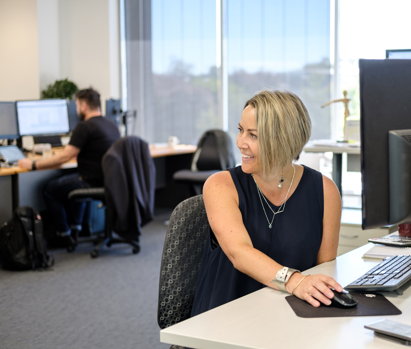 hero - A female Office 365 consultant at their computer, turning and smiling