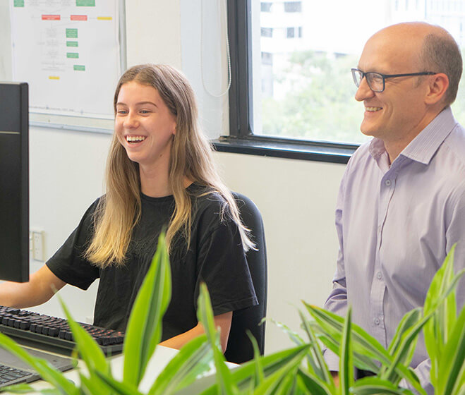 hero - A Office 365 expert assists a younger user on her computer, both are laughing