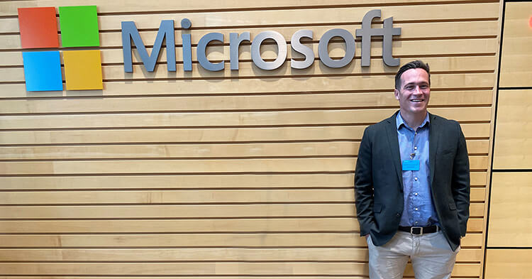 news - A New Zealand Office 365 consultant stands in front of the Microsoft logo